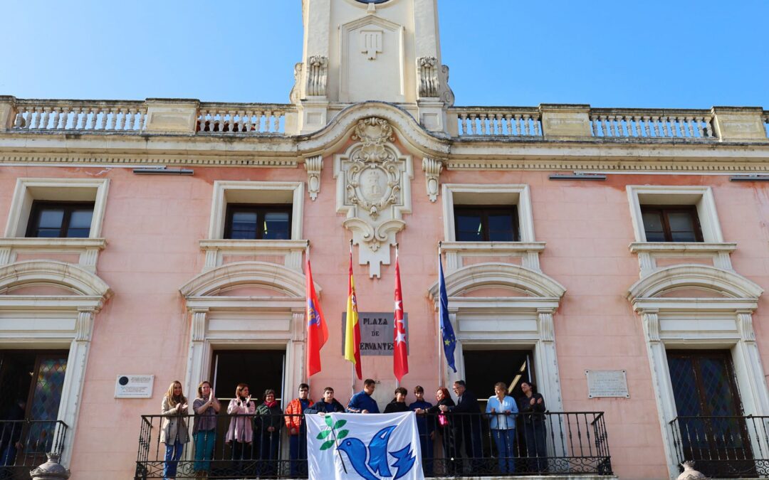 Alumnos del colegio Escuelas Pías colocan el símbolo la Paz en el balcón del Ayuntamiento de Alcalá
